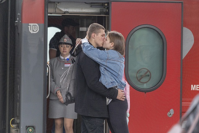 電車の前でキスする恋人